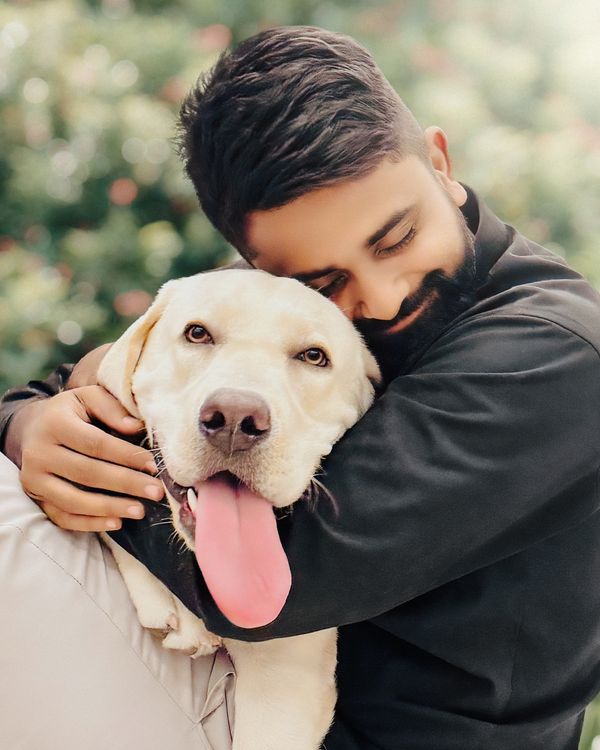 Labrador Man Man Embracing Labrador Retriever Outdoors · Free Stock Photo