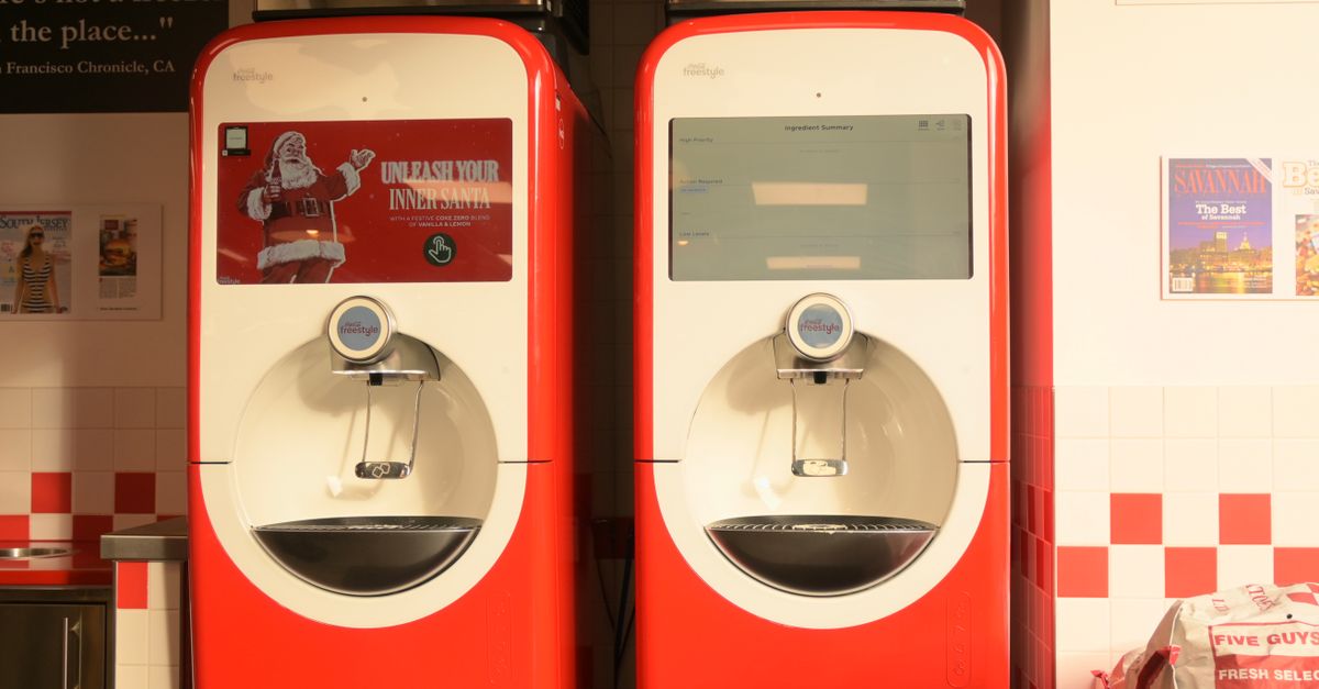 Coca-Cola Freestyle beverage dispensers in a restaurant with seasonal Santa branding.
