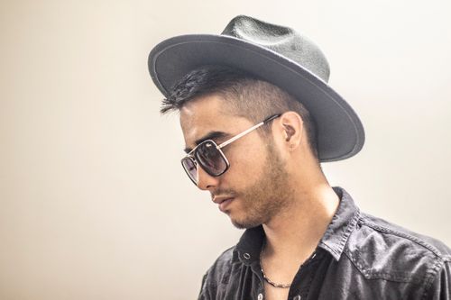 Free Fashionable young man wearing sunglasses and a hat, posing in a stylish outfit. Stock Photo