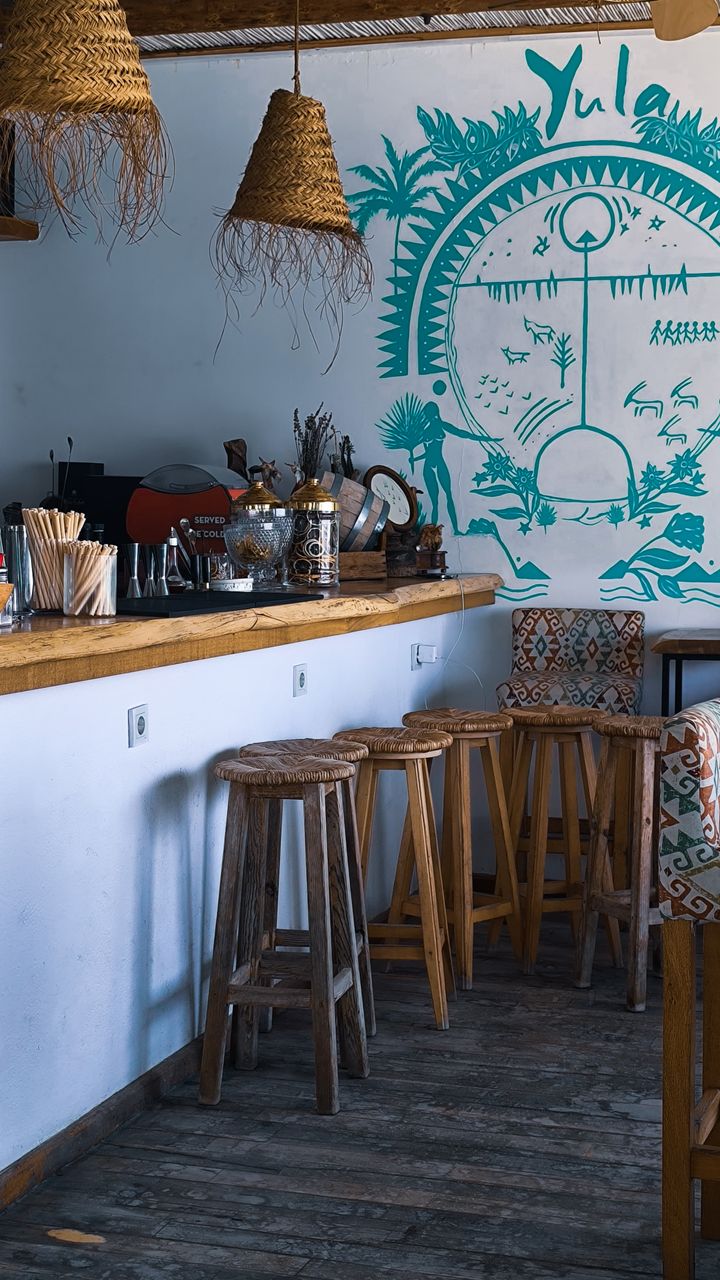 Distressed wooden coffee sign with hand-painted text displayed on a boho coffee bar shelf