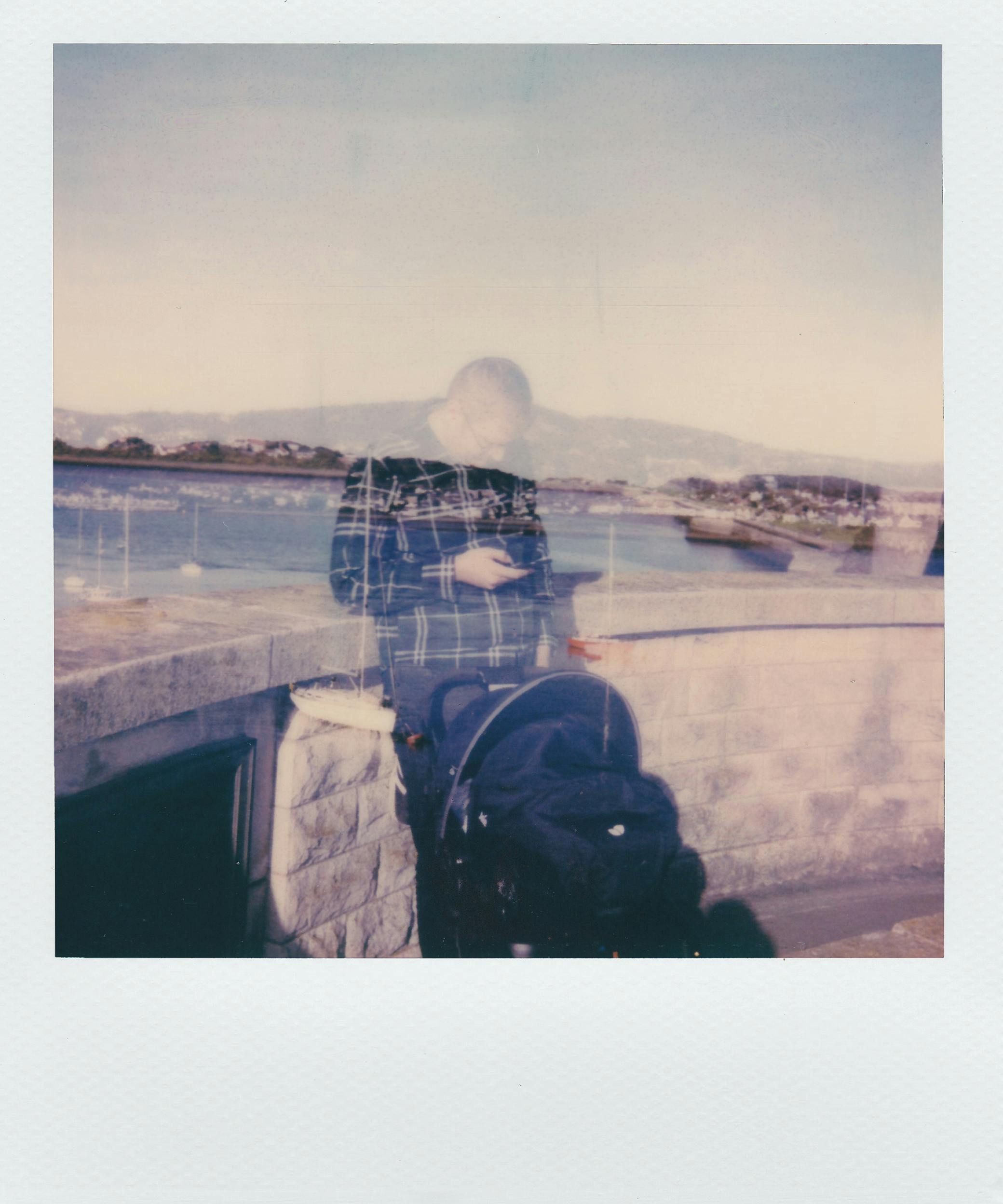 在海滨，一个人推着婴儿车，通过艺术双重曝光营造出空灵的氛围