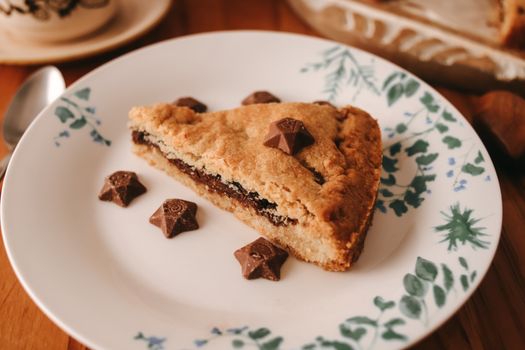 A slice of tart on a decorative plate with chocolate star toppings.