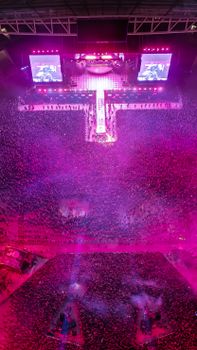 Aerial shot of a packed concert with vivid lighting and energetic atmosphere.