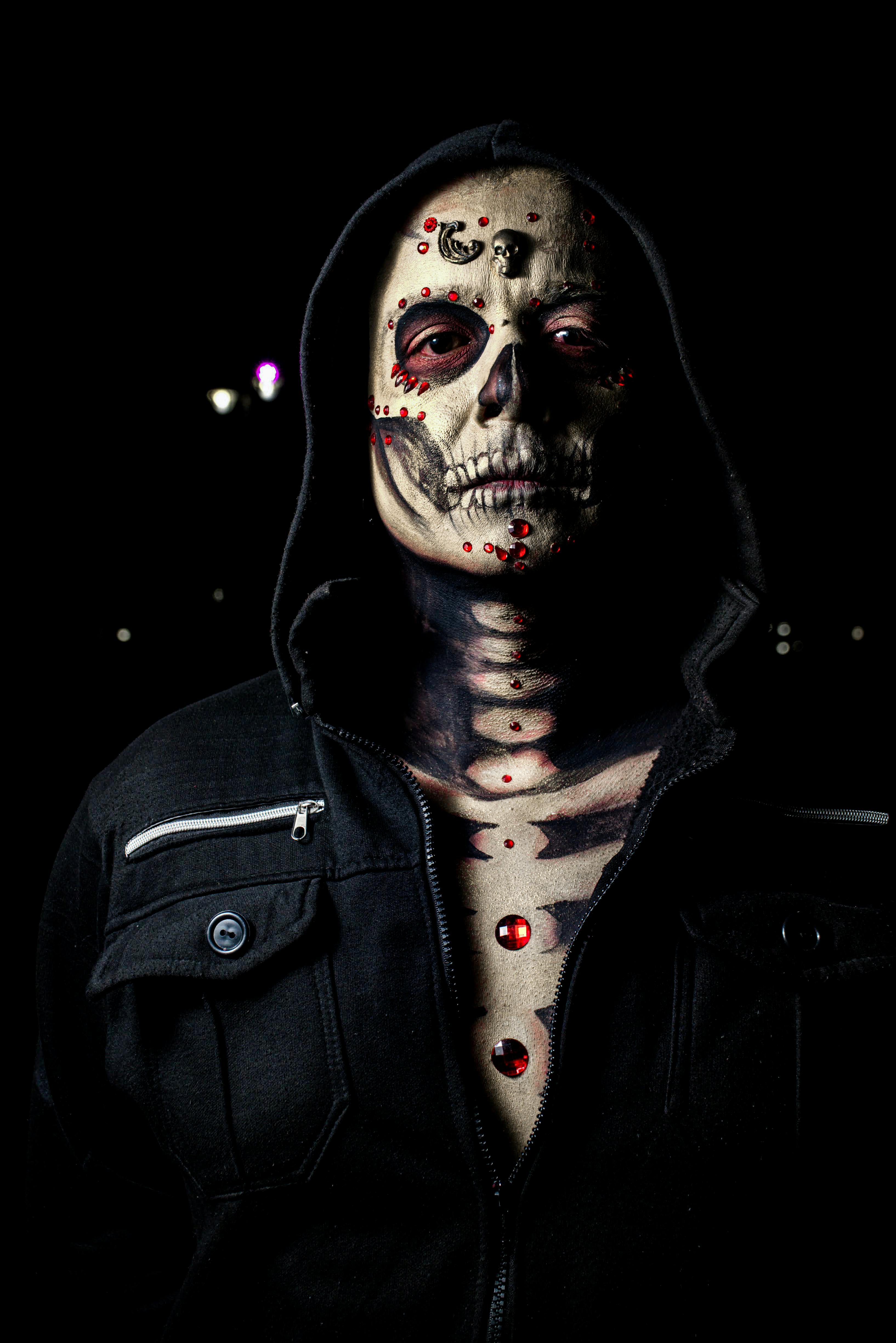 Ücretsiz Geceleyin kapüşon takan, karmaşık kafatası makyajlı bir kişinin ürkütücü portresi. Stok Fotoğraflar