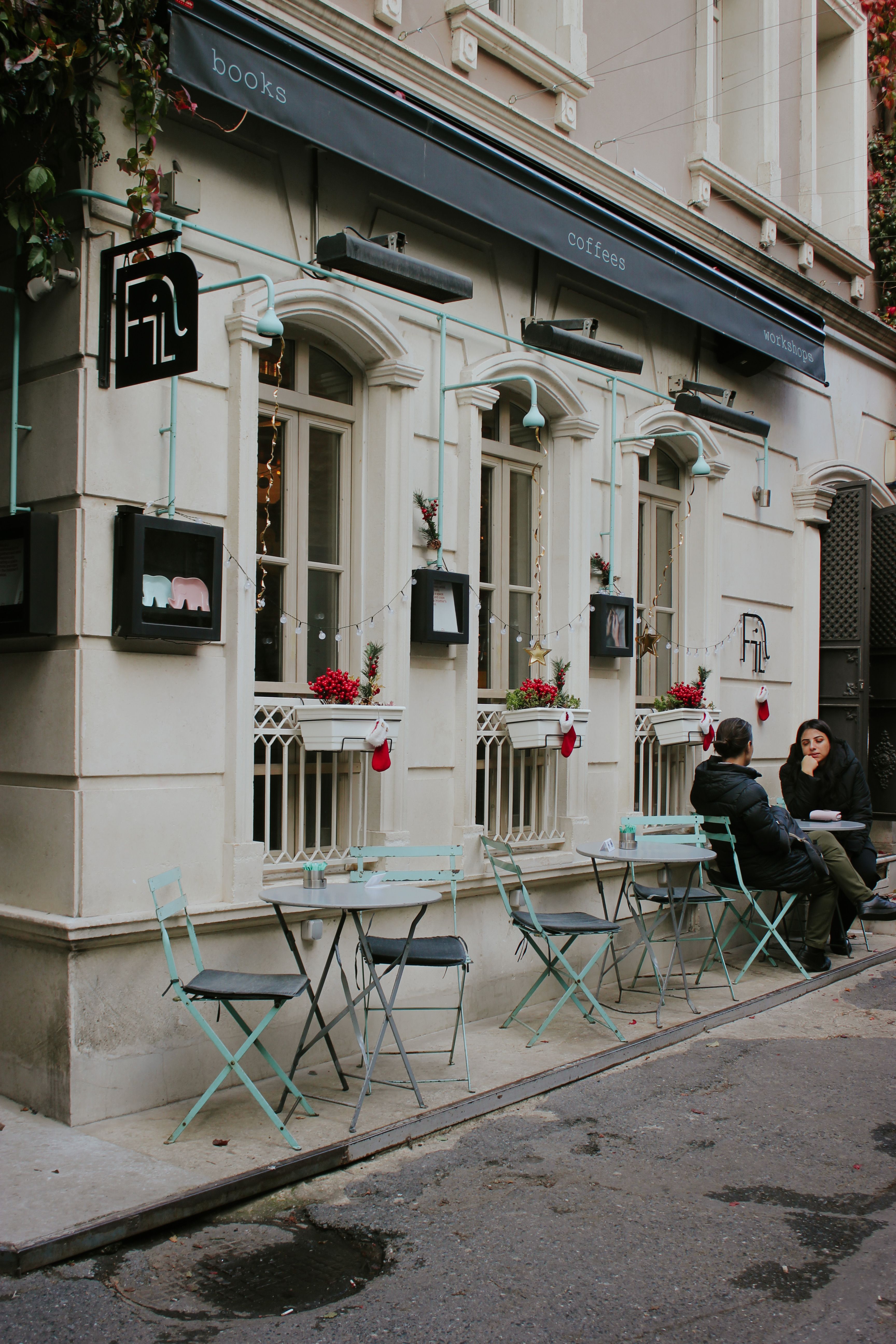 A cozy outdoor café setting with two people on a city street during the day.