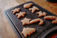 Close-up image of freshly baked Christmas gingerbread cookies cooling on a tray.