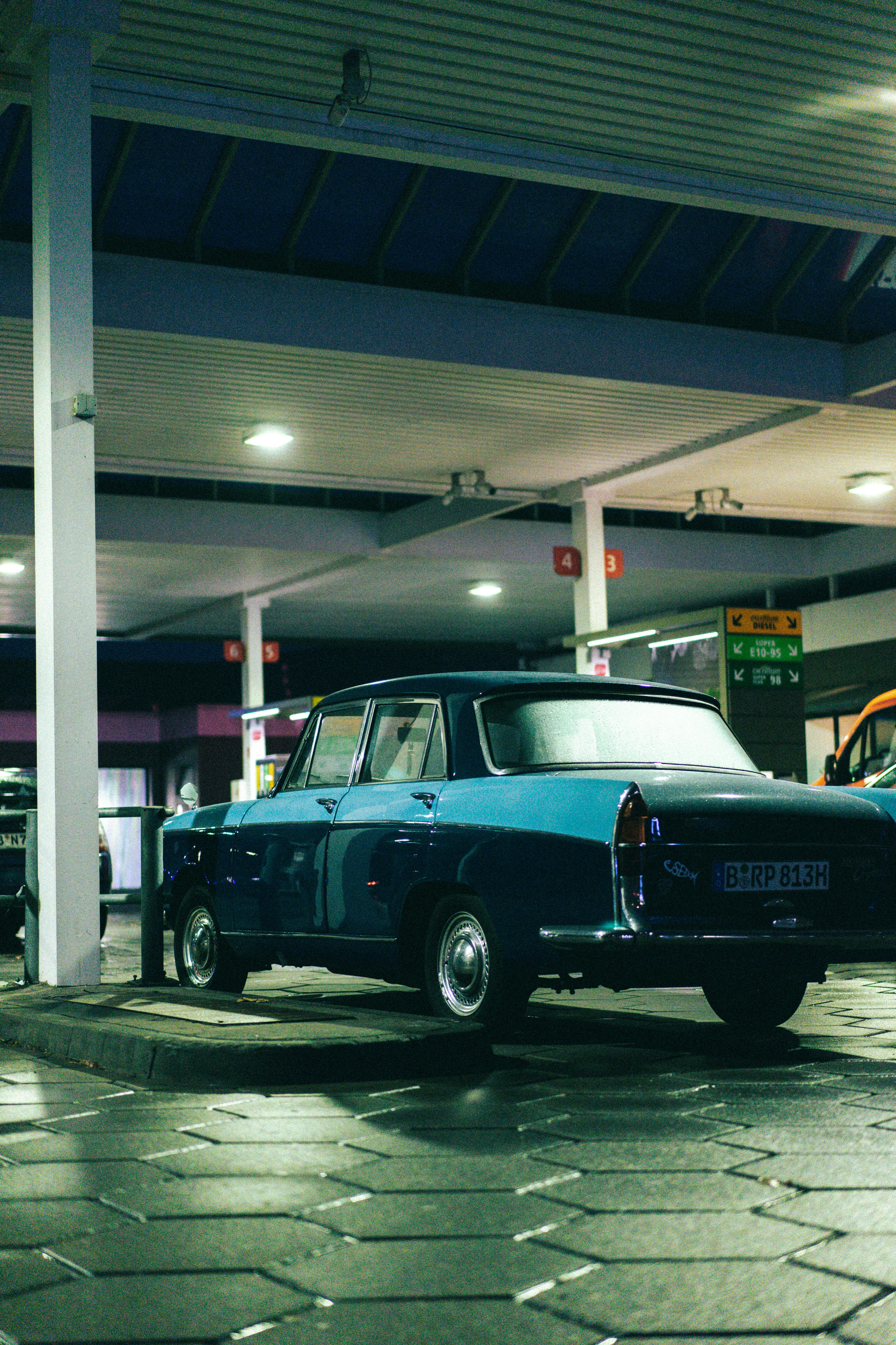 vintage car parked at berlin gas station at night