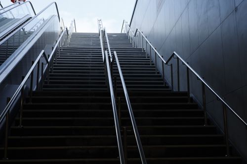 Free Upward view of a modern staircase leading towards the sky, depicting urban architecture. Stock Photo
