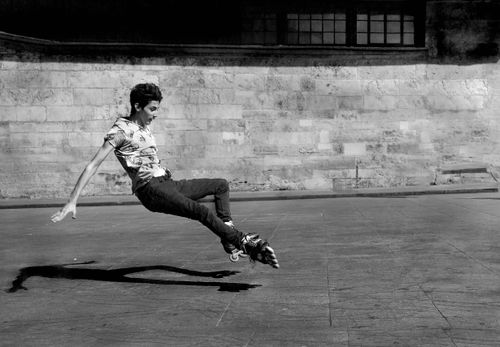 Free A young man skillfully rollerblades, captured in a dynamic black and white photo. Stock Photo