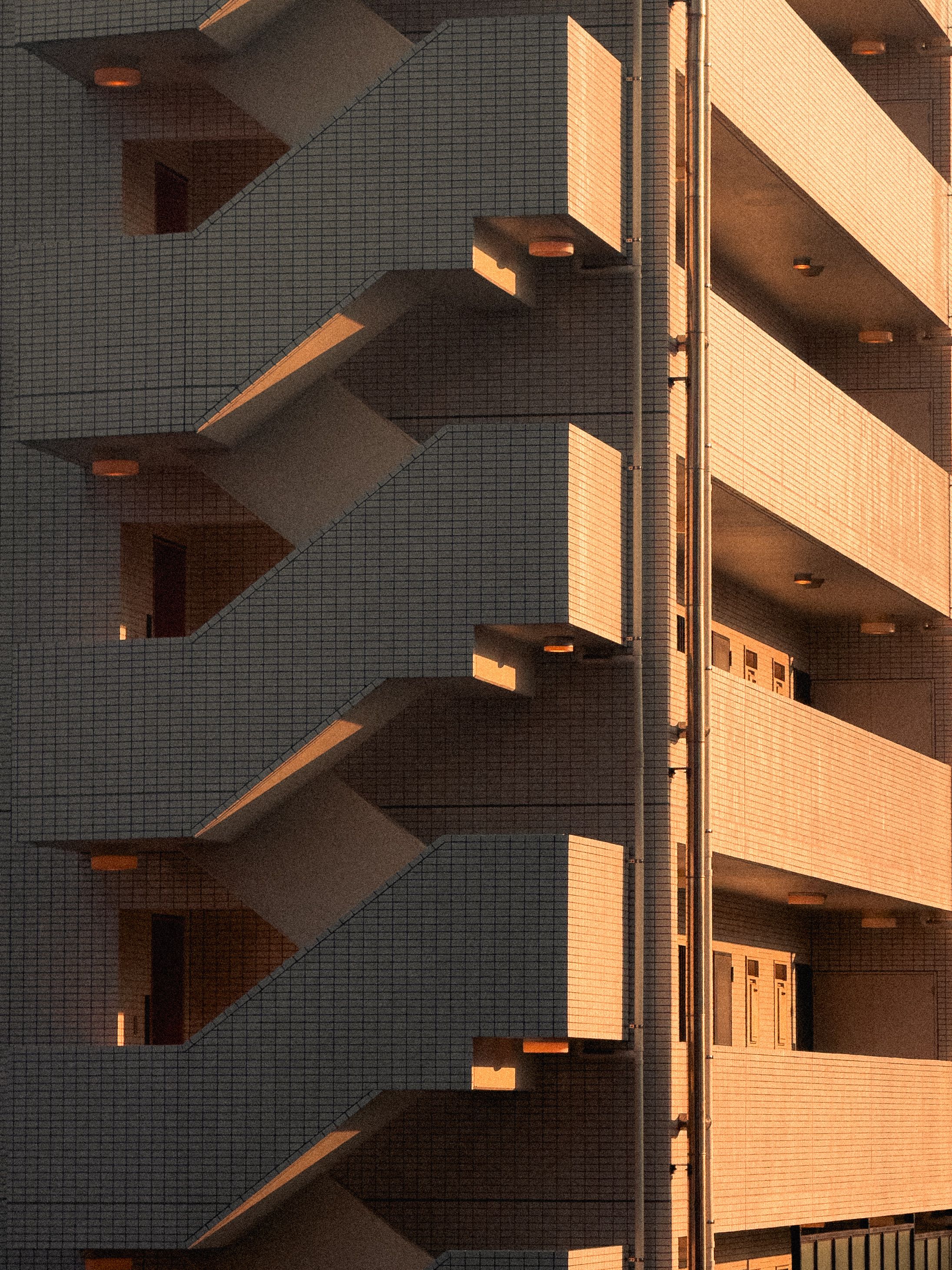 Captivating view of a modern apartment stairway in Tokyo during sunset, with unique geometric design.