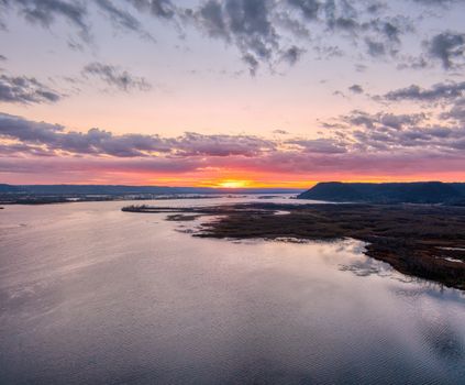 Scenic aerial view of Mississippi River during vibrant sunset with dramatic sky and reflections.