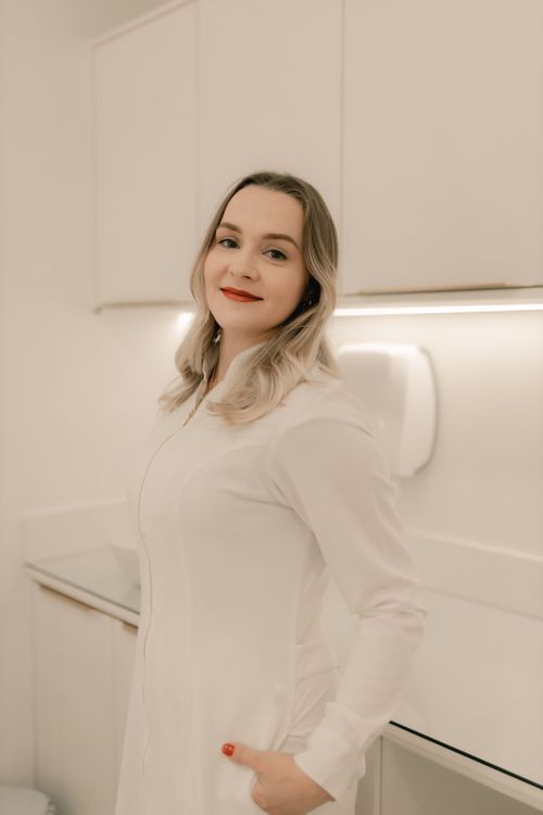 Free Portrait of a smiling woman in white in a bright, modern office. Stock Photo