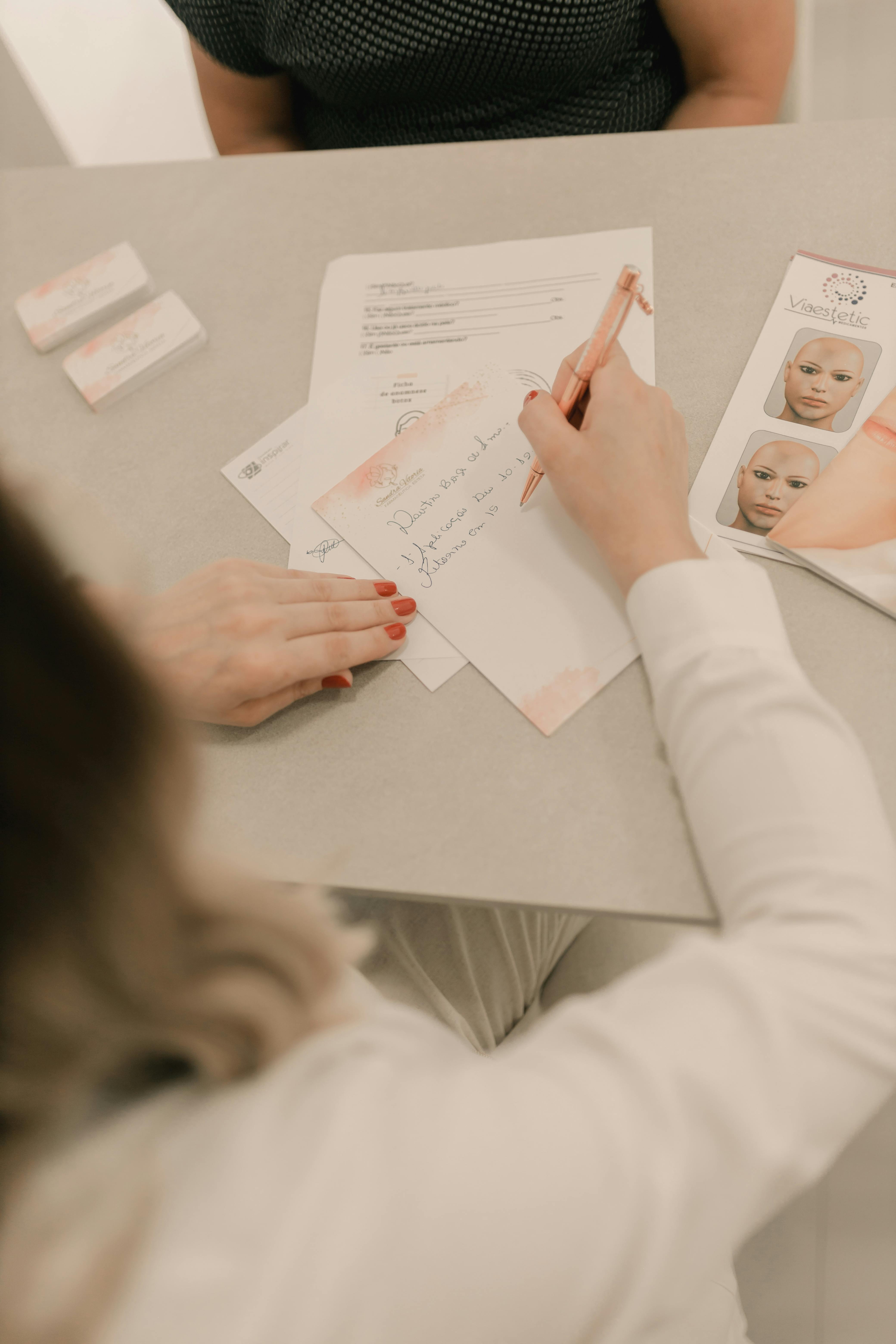 Woman writing notes during a beauty consultation indoors.