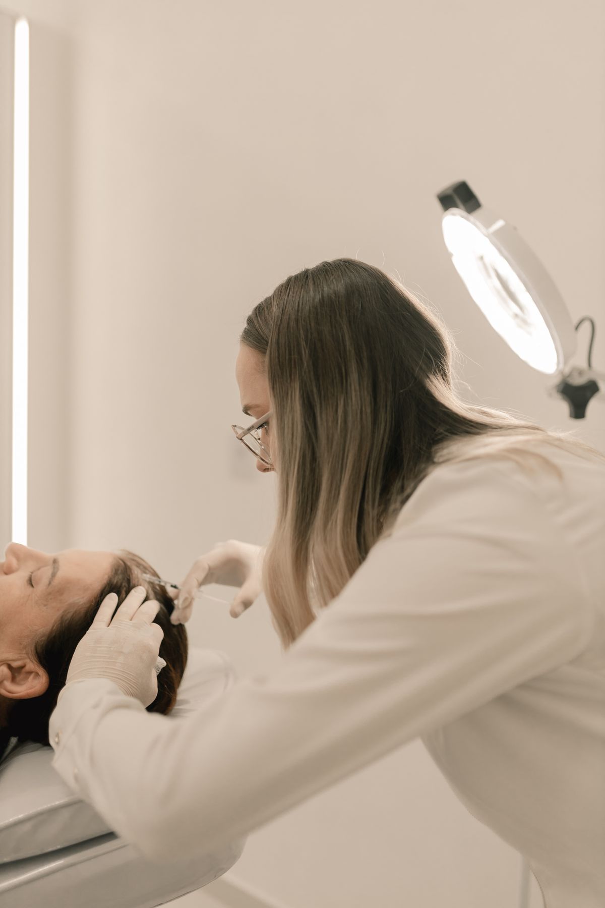 Trichologist examining scalp and hair health during clinical training