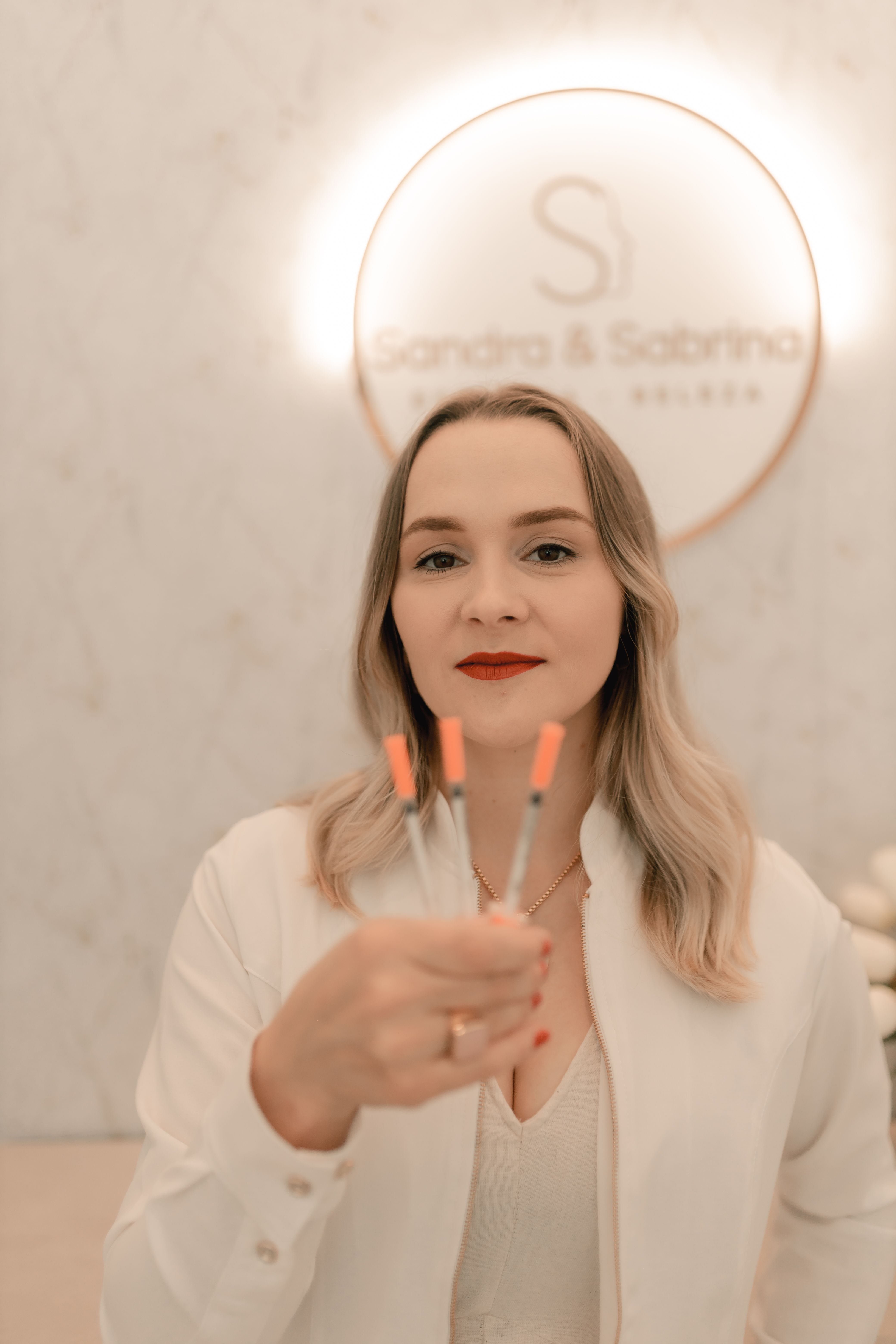 Professional woman presenting syringes in a medical clinic with a modern aesthetic.