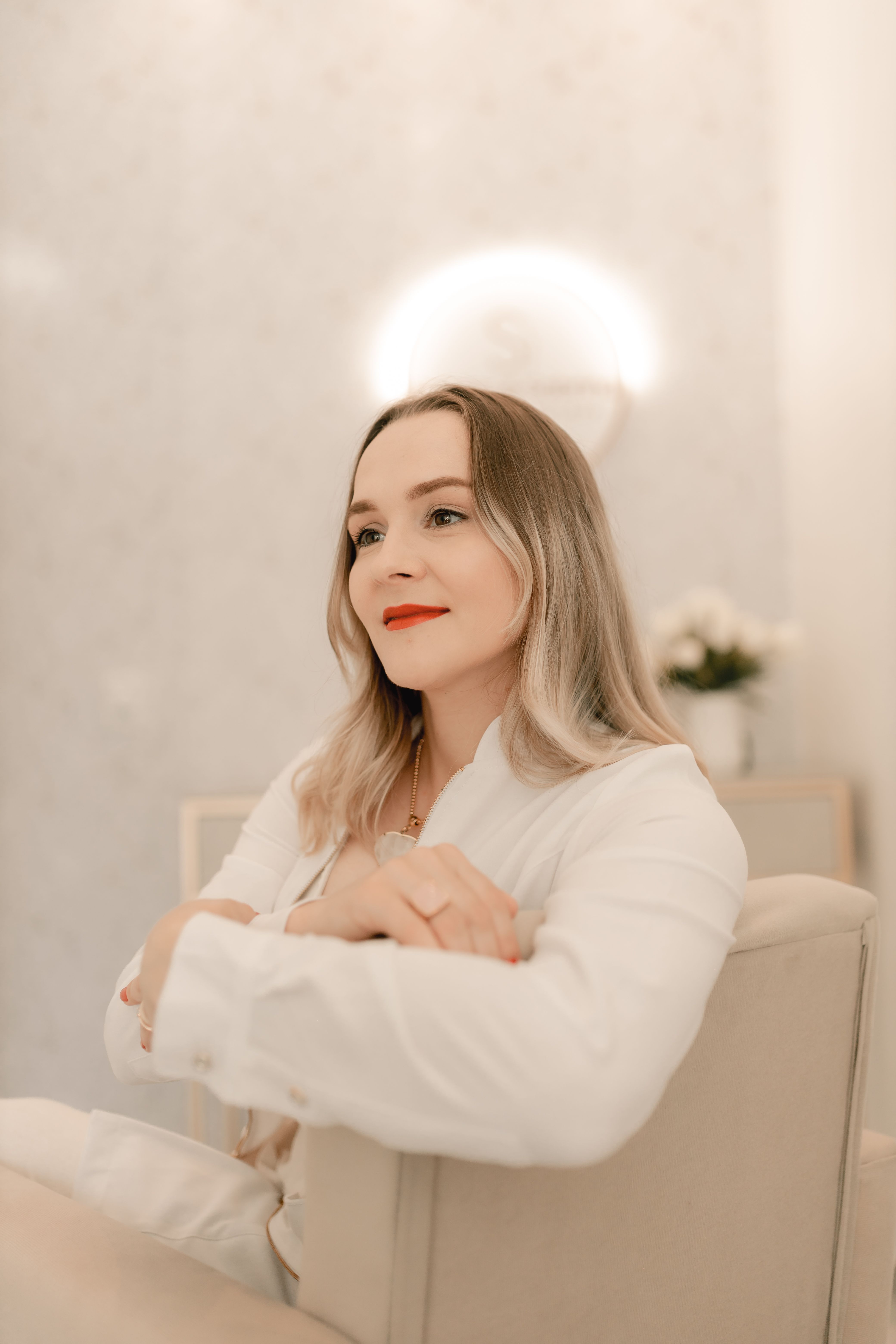 A serene portrait of a woman sitting in a comfortable setting, exuding relaxation and confidence.