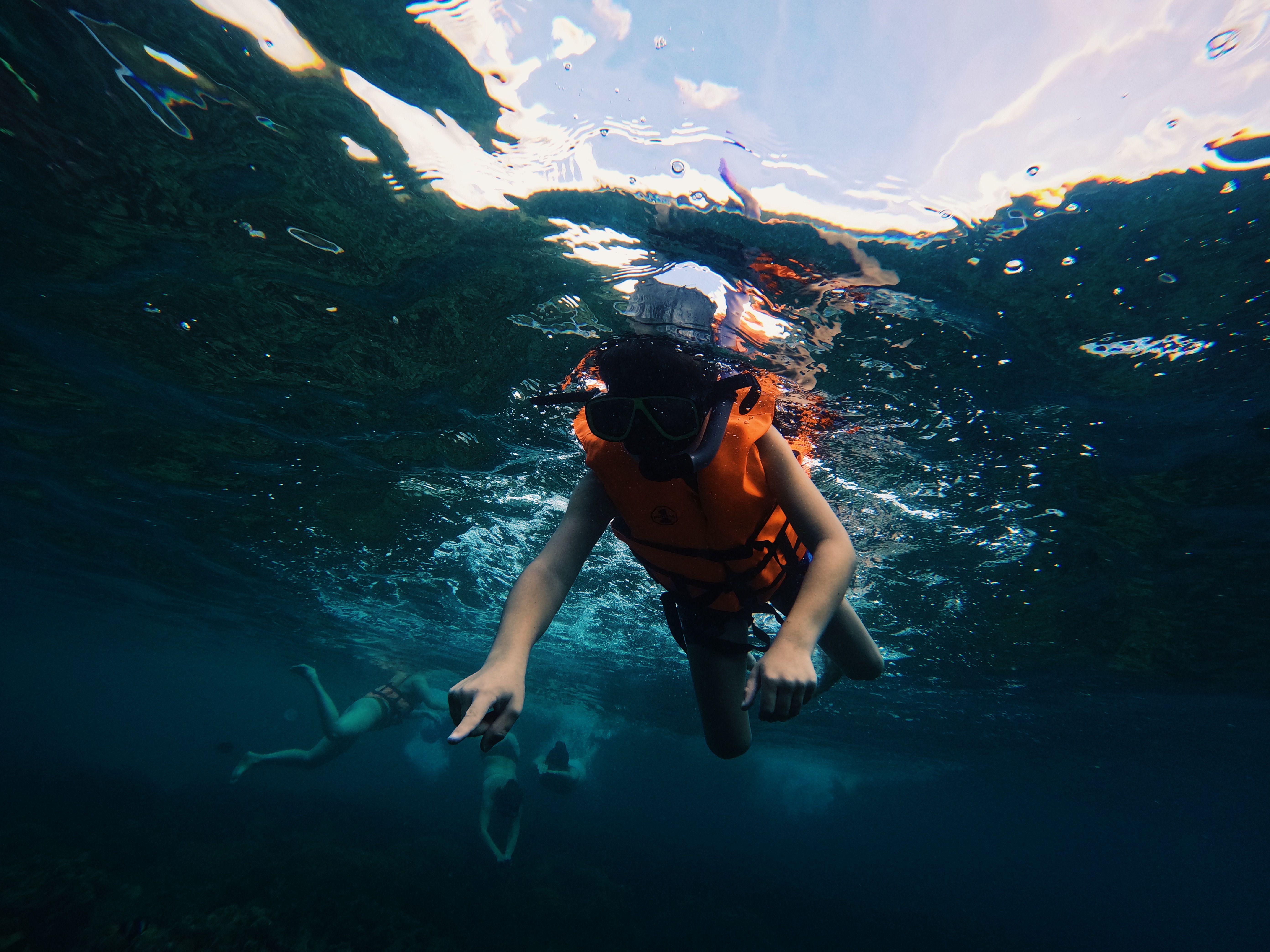 Kinder beim Schnorcheln mit UV-Schutzshirt im Meer