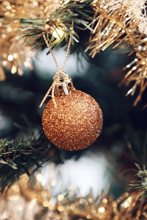 Free Close-up of a golden Christmas bauble hanging on a decorated tree branch in Jönköping, Sweden. Stock Photo
