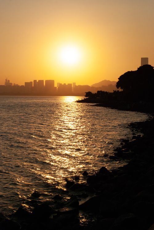 Free Beautiful sunset over the Shenzhen skyline with reflective waterfront, capturing the serene ambiance of the city. Stock Photo