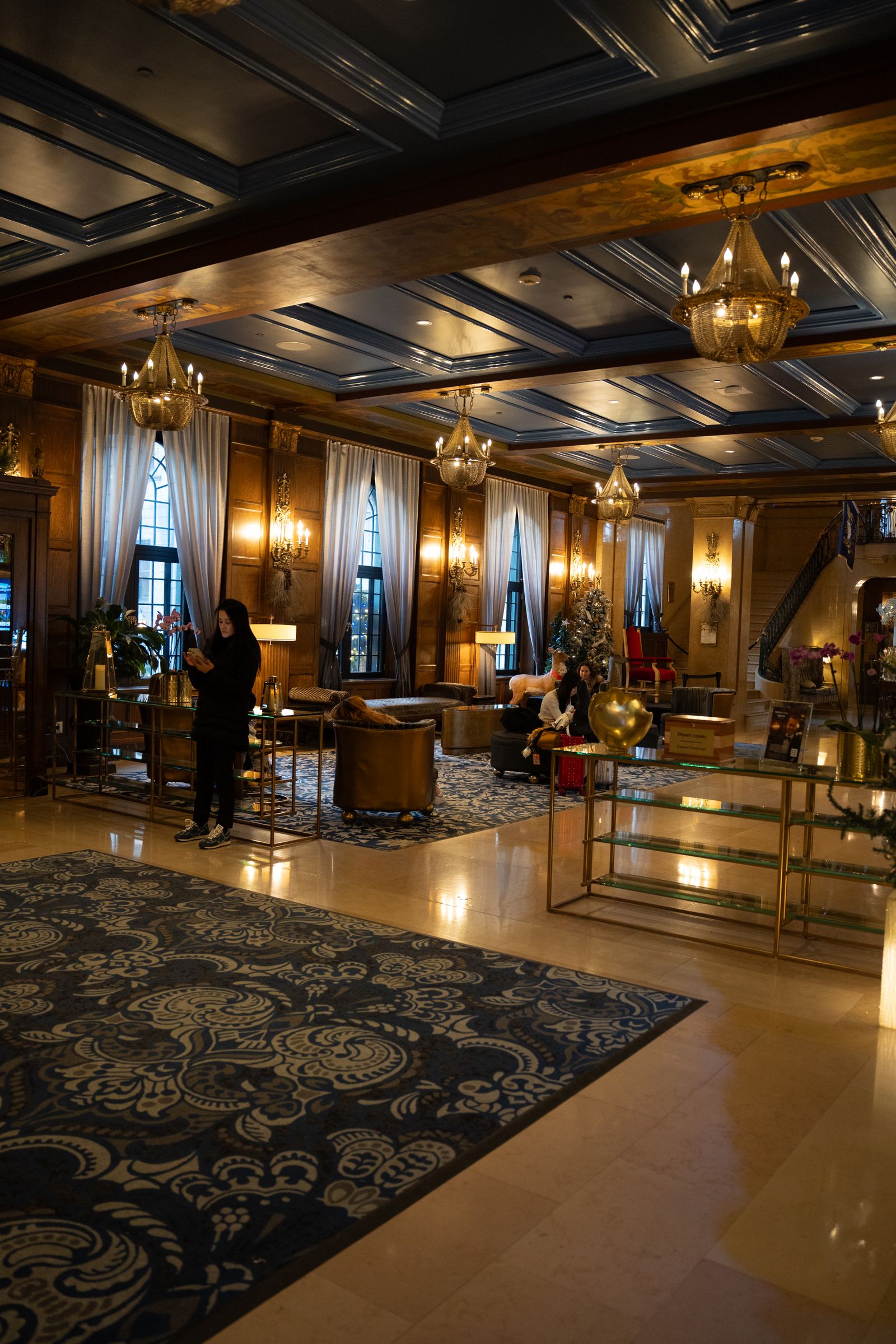 An ornate hotel lobby with grand chandeliers and vintage decor