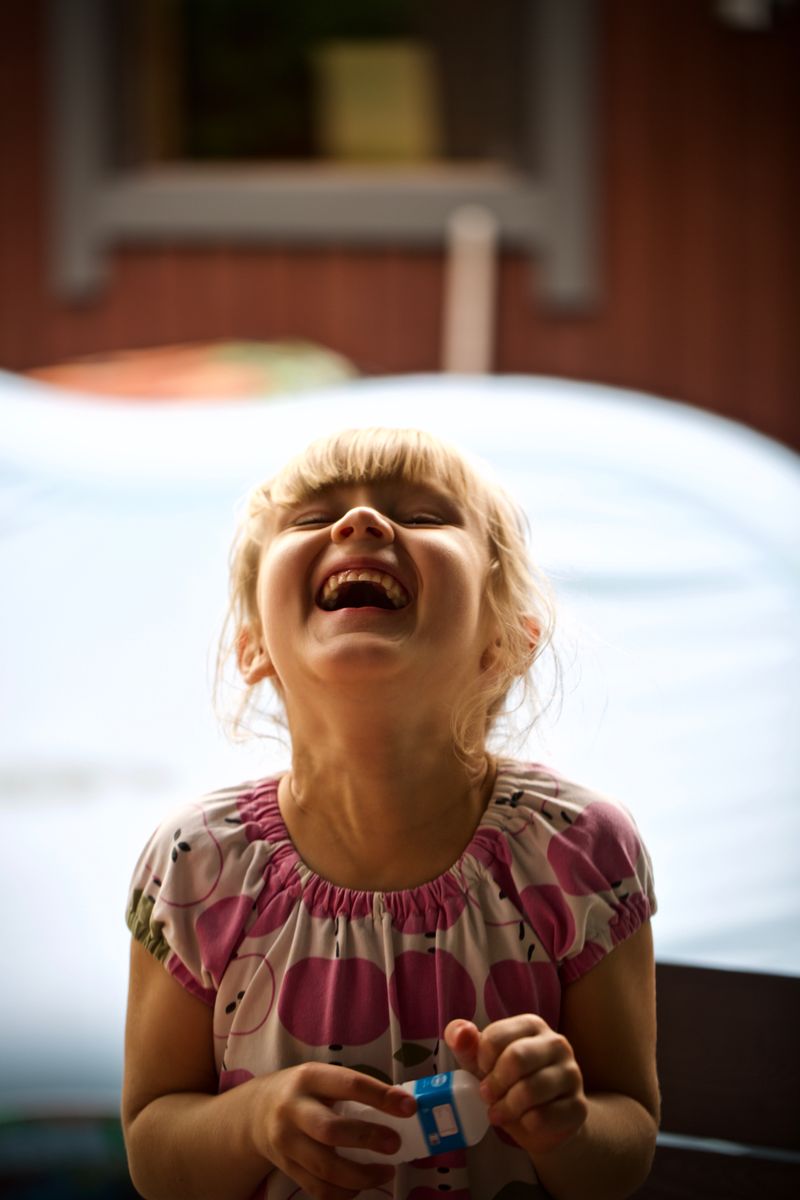 A young girl bursting into laughter outdoors — photo by Marko Tuokko on Pexels