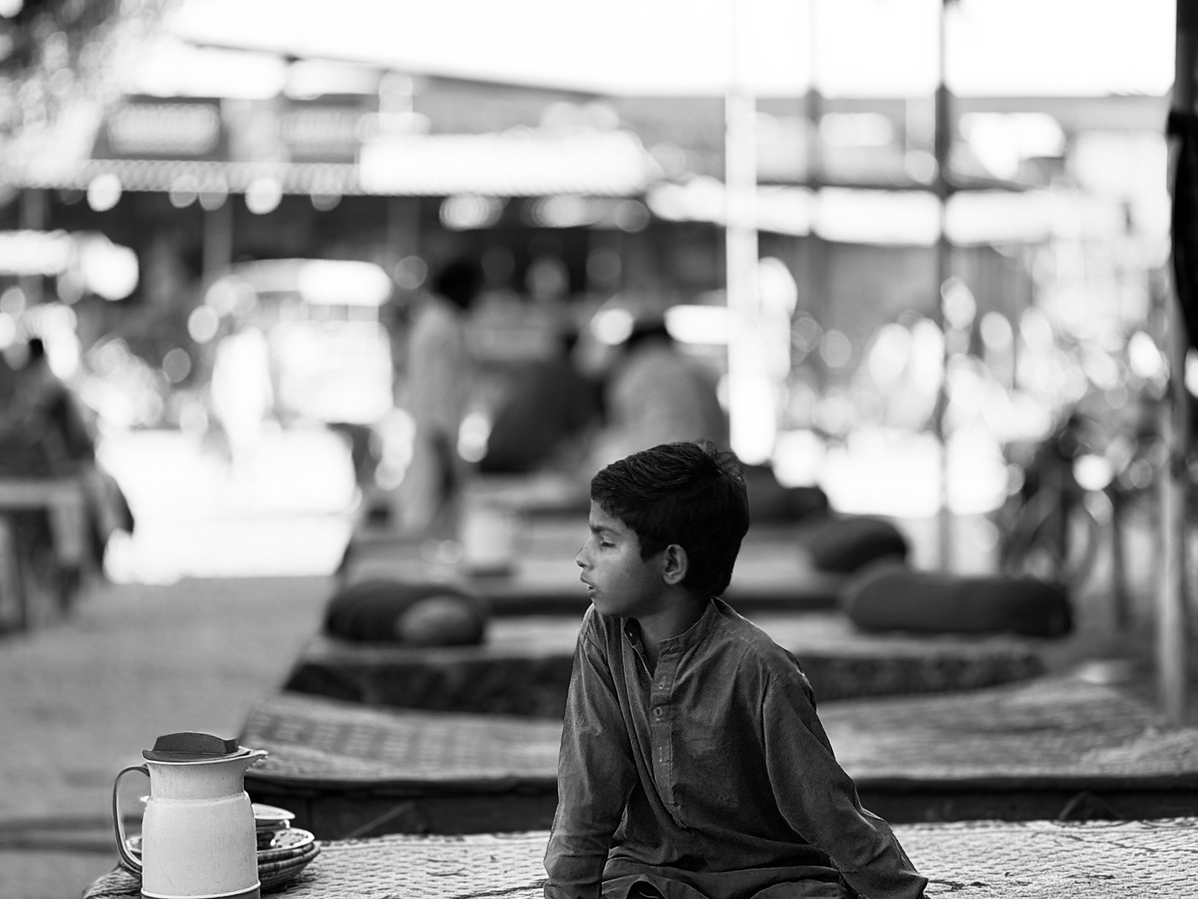 Contemplative Child in Pakistani Street Market · Free Stock Photo