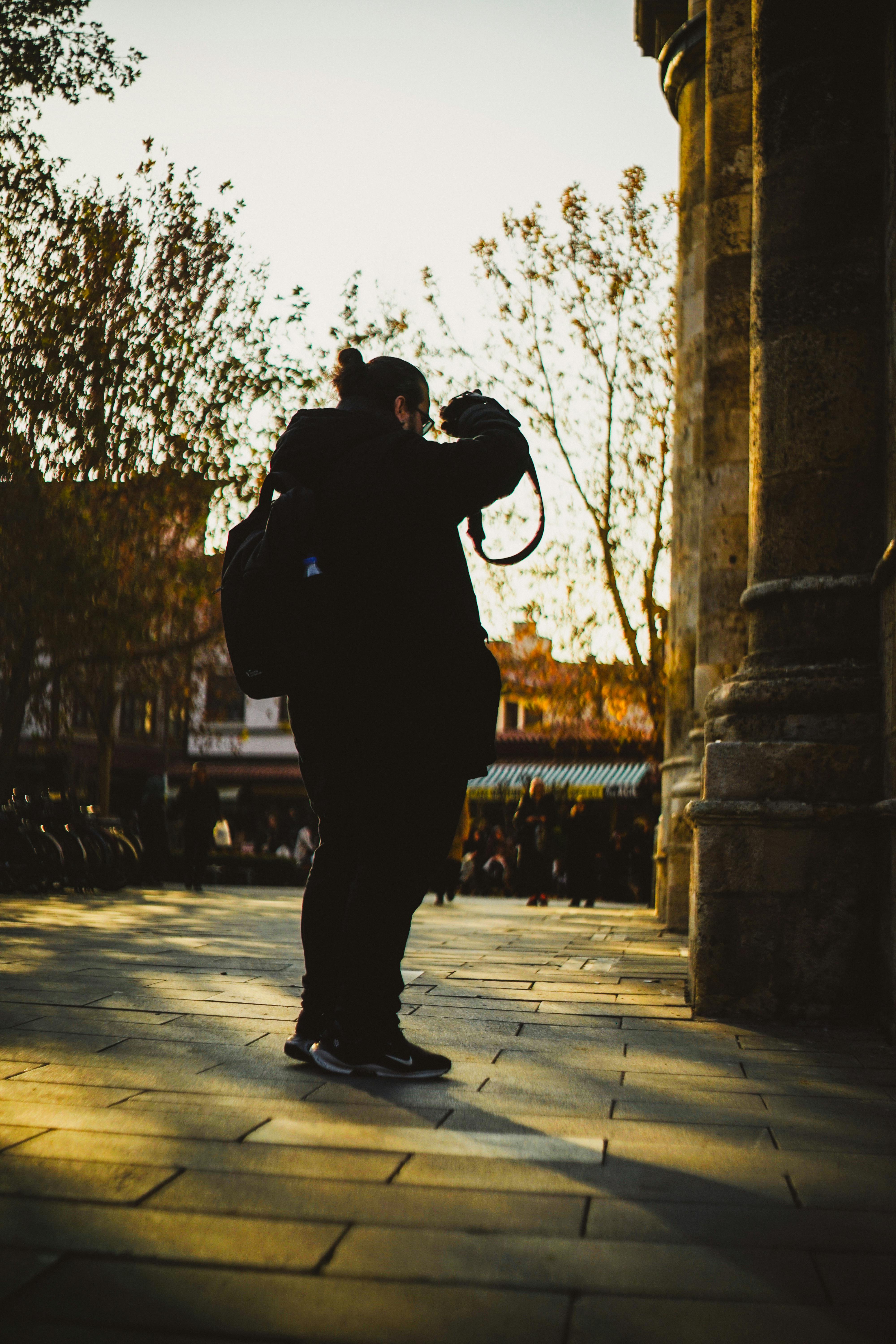 silhouette of photographer in urban setting at sunset