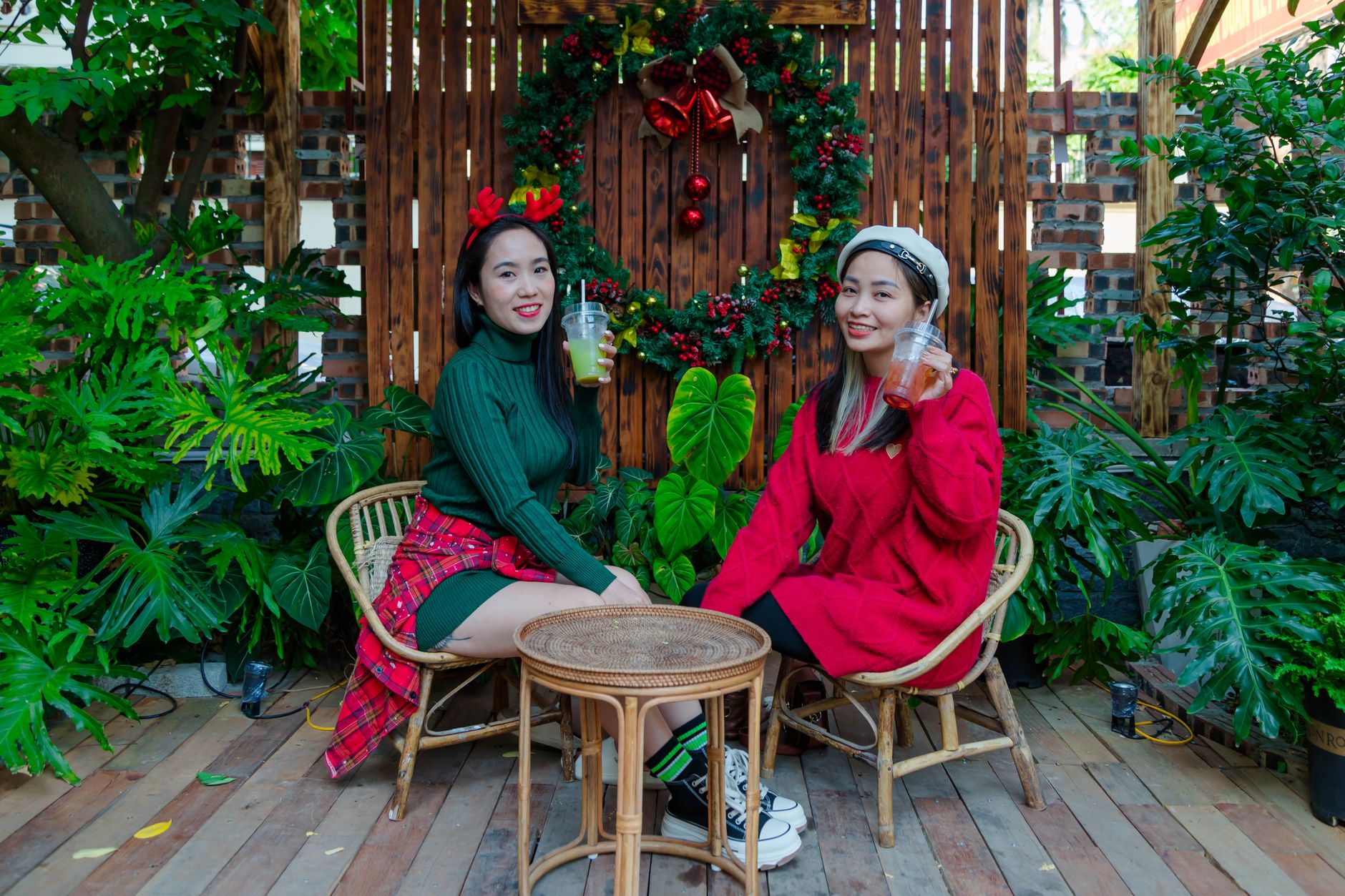 Two women celebrating Christmas in HαΊ£i PhΓ²ng with festive outfits and drinks.
