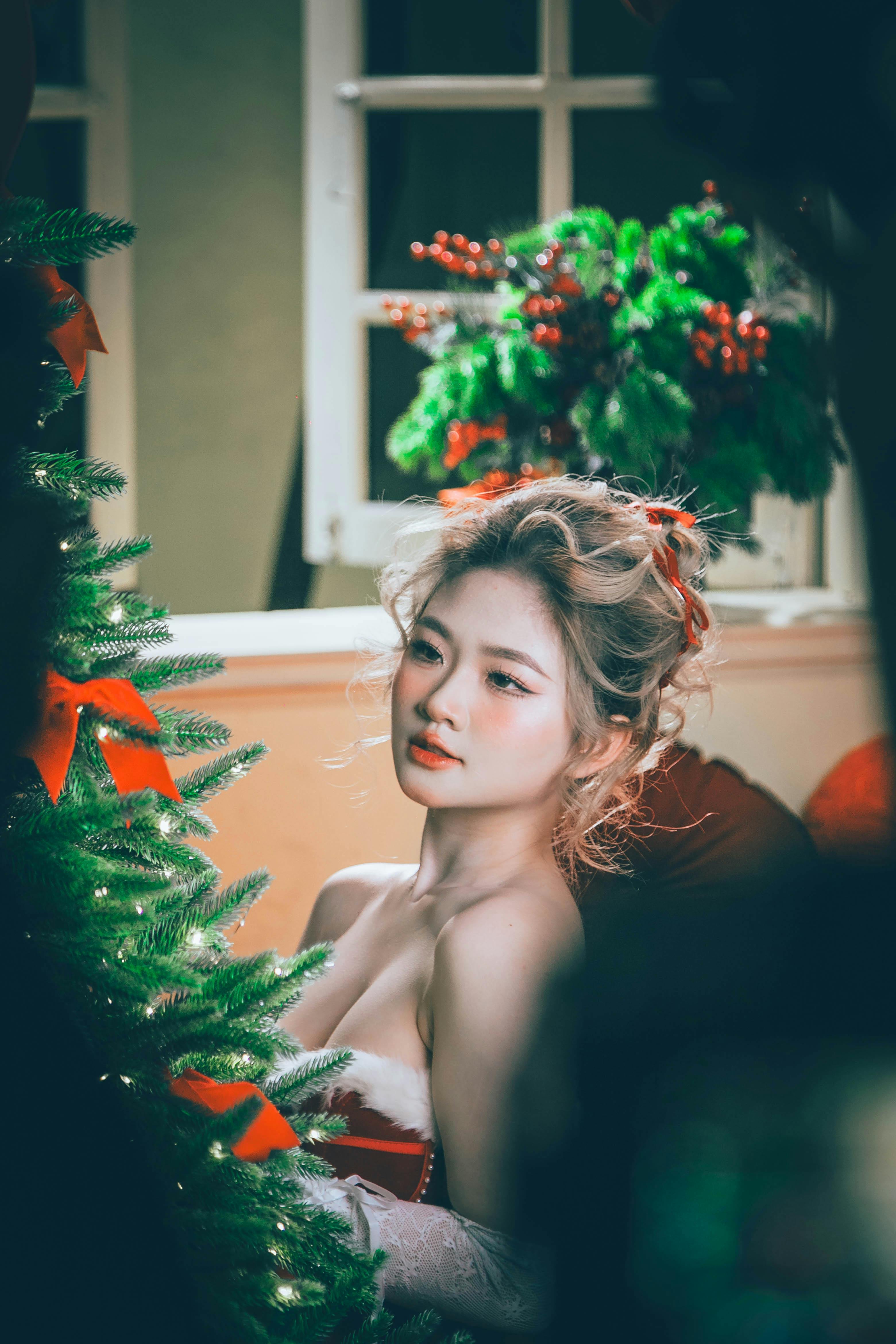 Celebratory indoor portrait of a woman surrounded by Christmas decorations in Hải Phòng.