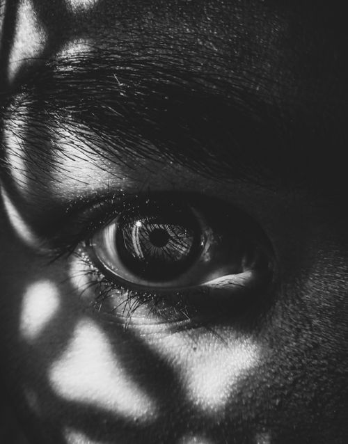 Free Striking black and white close-up of an eye with dramatic lighting and shadows. Stock Photo