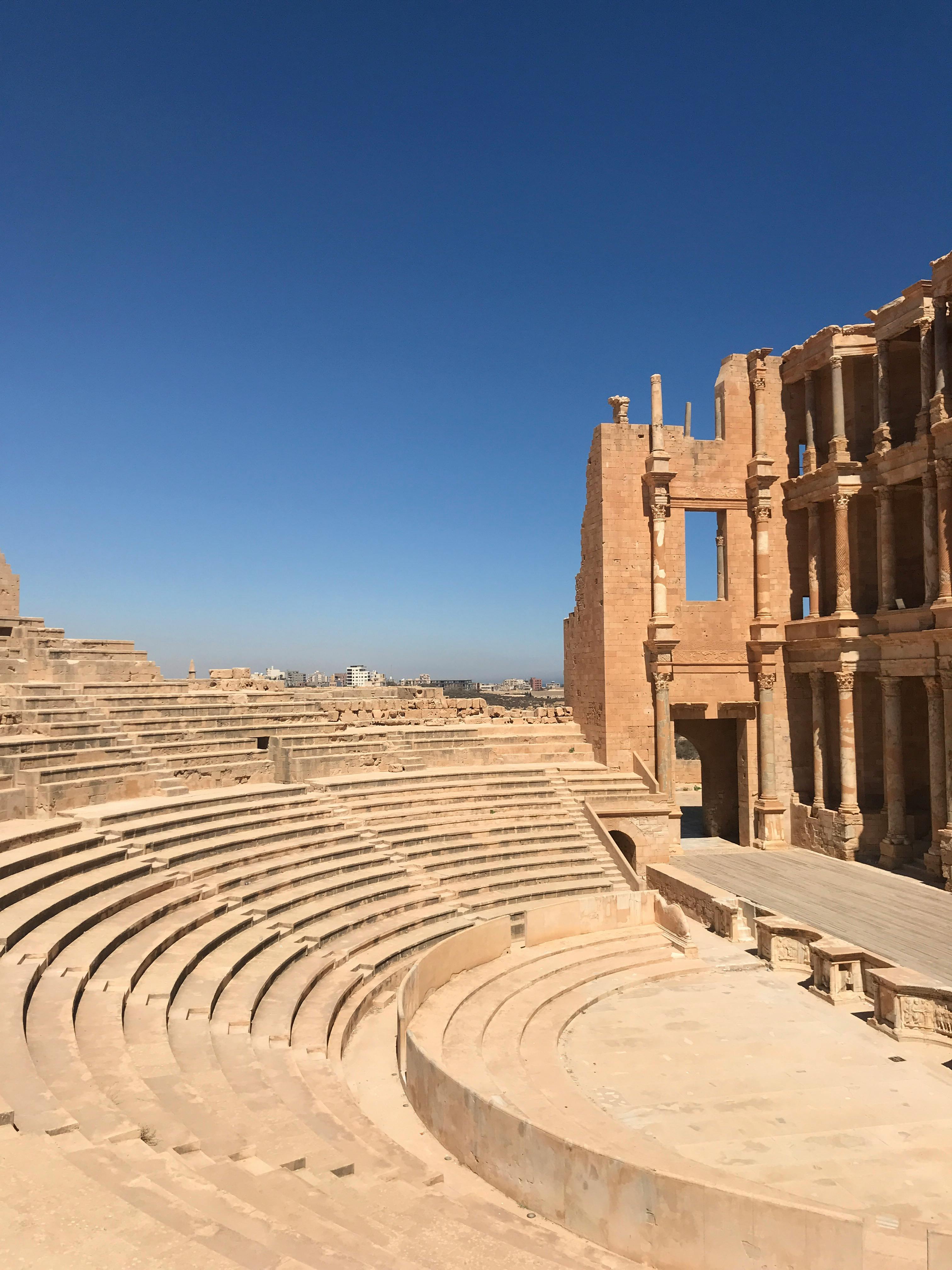 Kostenlos Erkunden Sie die Ruinen des antiken römischen Theaters in Sabratah, Libyen unter einem klaren blauen Himmel. Stock-Foto