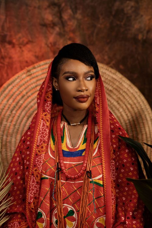 Free Portrait of a woman in vibrant African traditional wear with cultural jewelry. Stock Photo