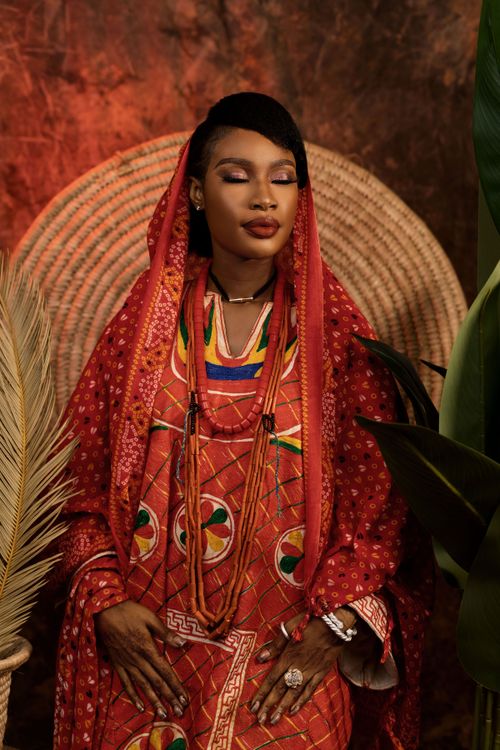 Free Portrait of a woman in vibrant traditional African clothing, evoking cultural richness and elegance. Stock Photo