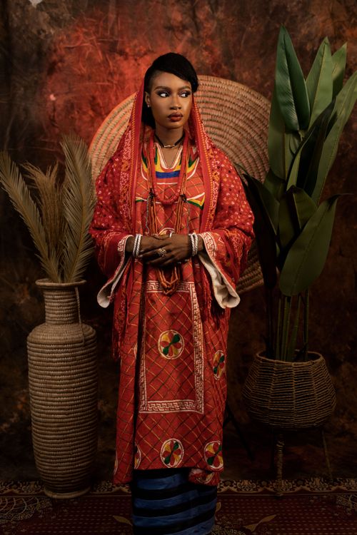 Free Elegant woman in vibrant African clothing with cultural background elements. Stock Photo