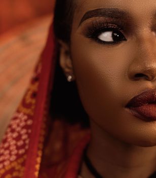 Close-up portrait capturing elegance and beauty with red fabric accent.