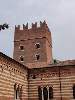 一座拥有独特拱形窗户和装饰性城垛的砖砌古塔，风景别致