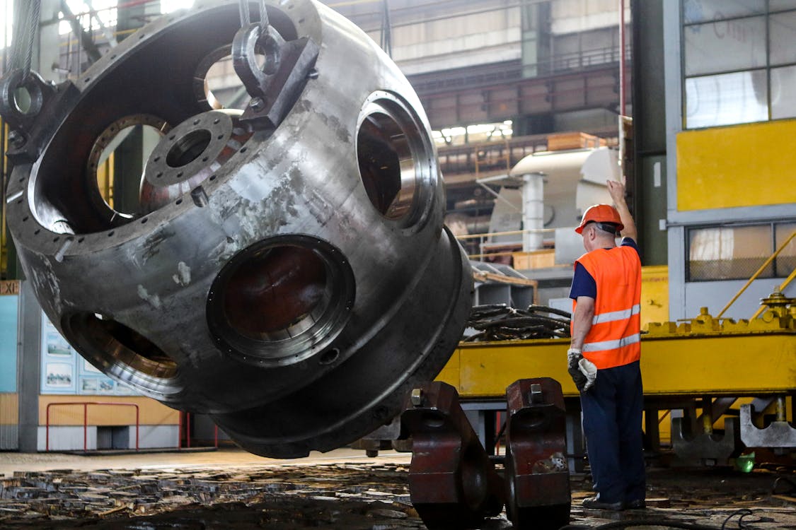 Free Man Standing in Front of Gray Metal Machine Part Stock Photo