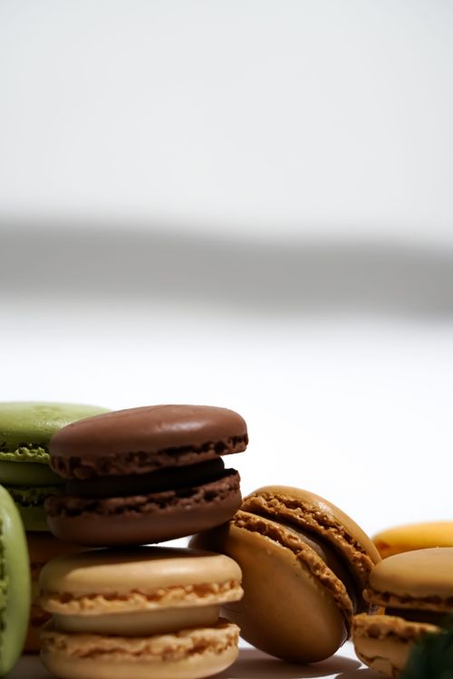 Free Close-up of colorful macarons stacked on a white surface, showcasing a minimalist and artistic look. Stock Photo