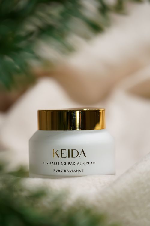 Free Elegant presentation of Keida Revitalising Facial Cream amidst soft textures and greenery. Stock Photo