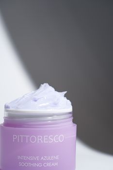 Close-up image of a soothing lavender azulene cream in a stylish purple jar.