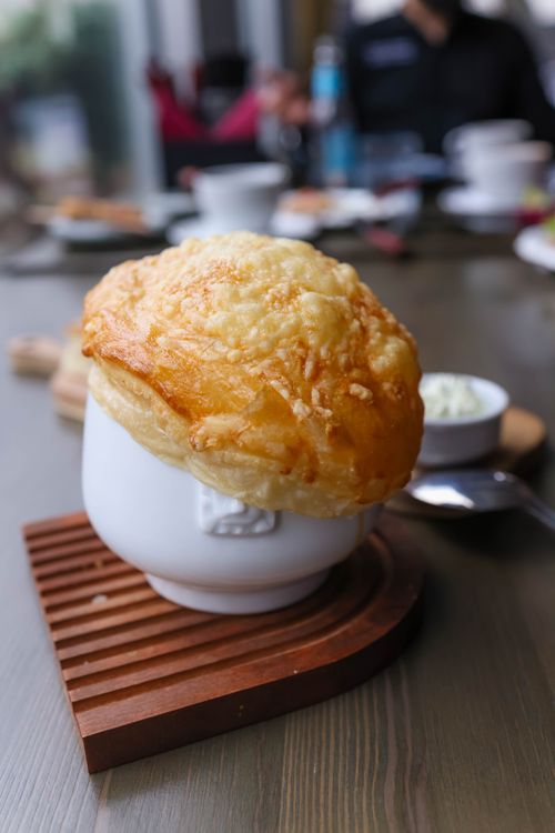 Free Close-up of French onion soup served in a white bowl with cheese crust. Stock Photo