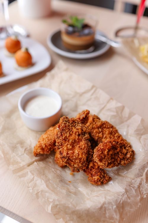 Free Delicious crispy fried chicken with dipping sauce, perfect for entertaining or casual dining. Stock Photo