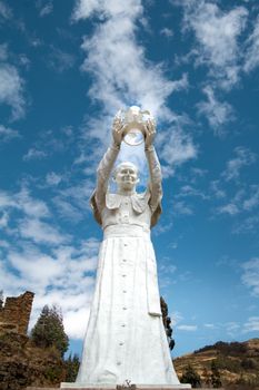 Majestic white statue in Paucartambo, Peru with a clear blue sky background.