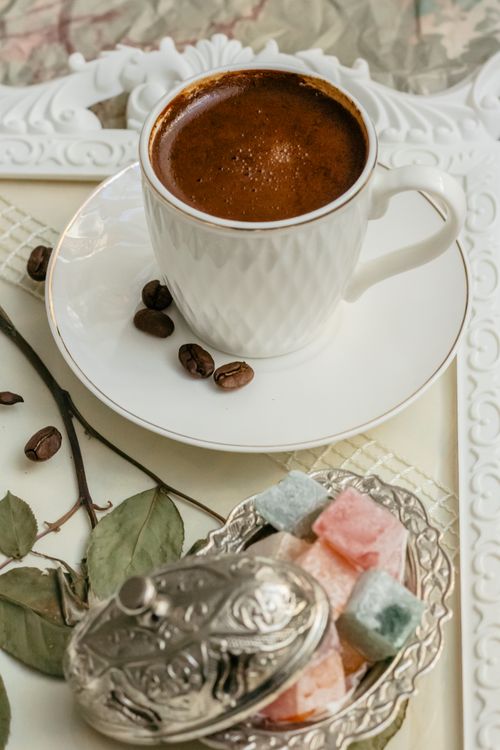 Free Cup of Turkish coffee with Turkish delight on ornate tray. Warm tones and inviting mood. Stock Photo
