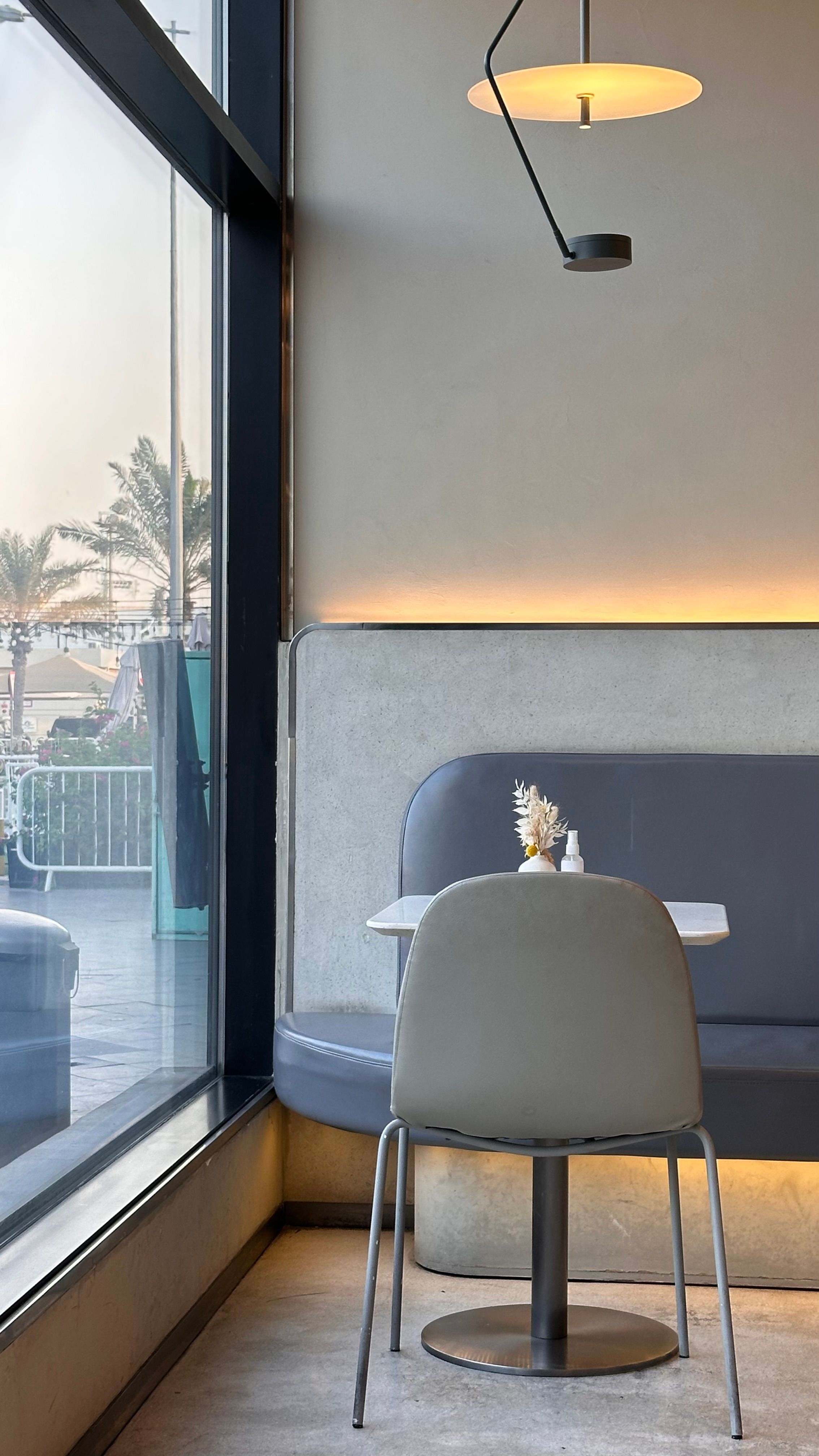 Cozy cafe with modern design in Doha, Qatar, featuring a single chair and table by the window.