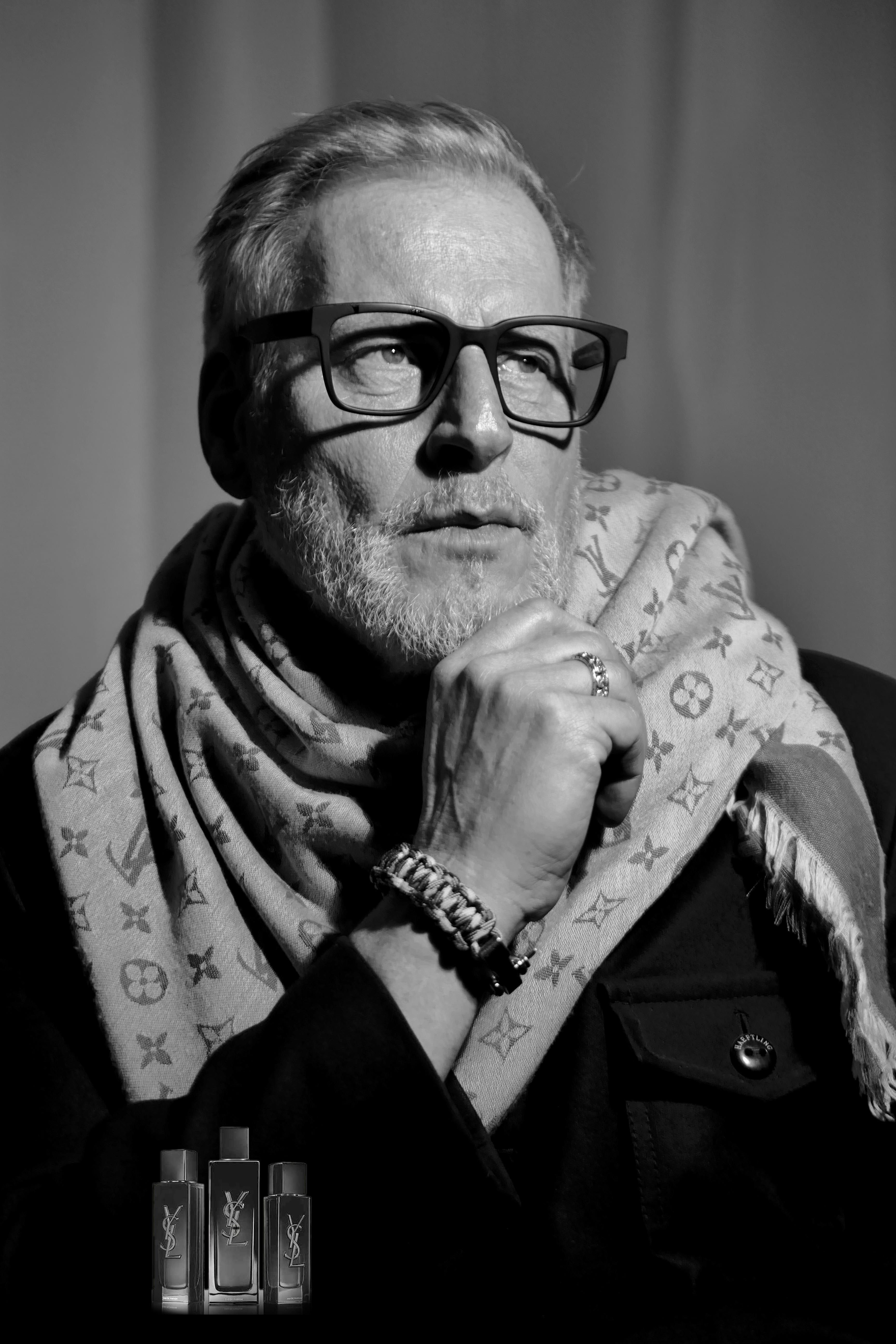 Black and white portrait of a man in glasses with a fashionable scarf.