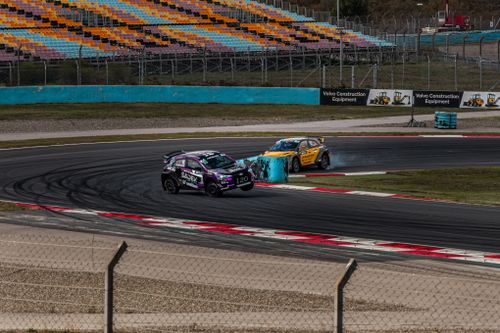 Free Dynamic shot of rally cars drifting on a race track corner, with colorful stands. Stock Photo