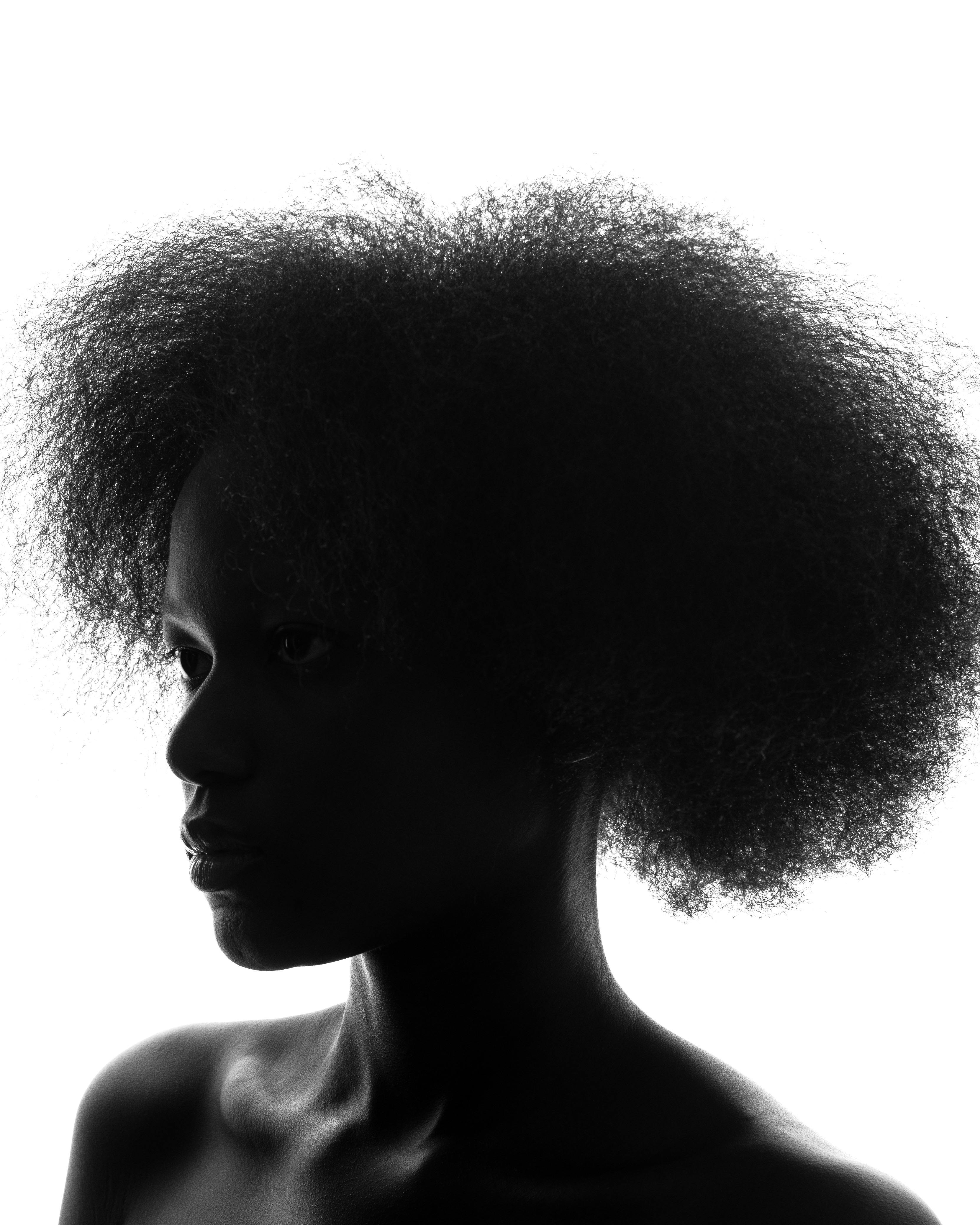 Black and white silhouette of a person with textured hair, highlighting shape and texture.
