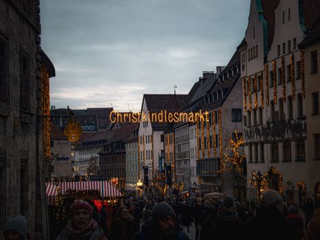 Evening view of the bustling Christkindlesmarkt in Germany, glowing with festive lights and winter charm.