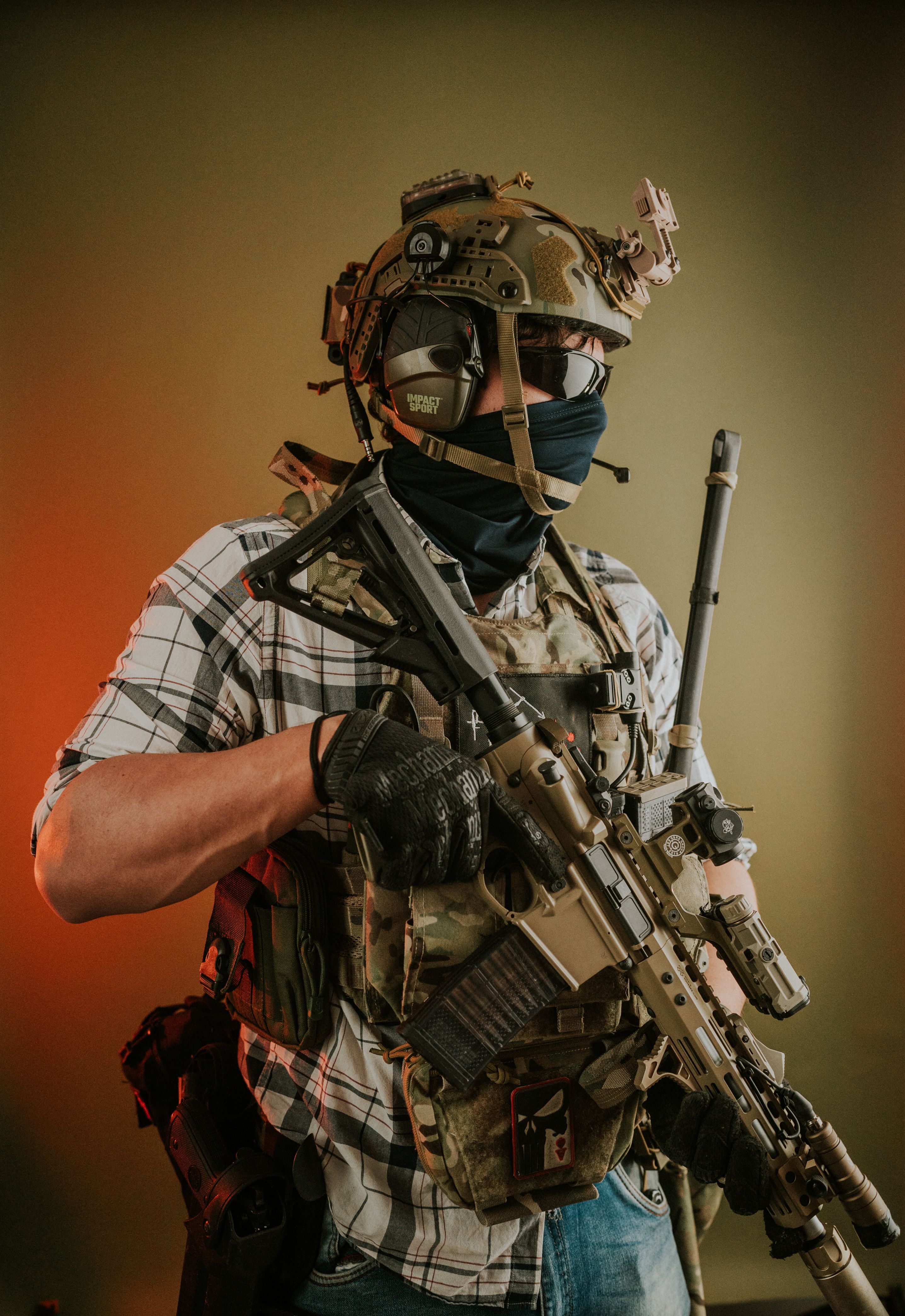 A soldier in full tactical gear and helmet holding a rifle, ready for action.